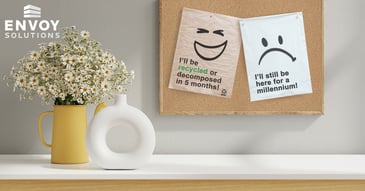 A cork board with smiling and angry  mailers with recyclability phrase on them on the office wall
