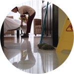 A housekeeping cleaning a hotel room with caution wet floor sign in front of the door