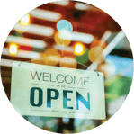 A circular image with welcome we are open sign on the retail store door